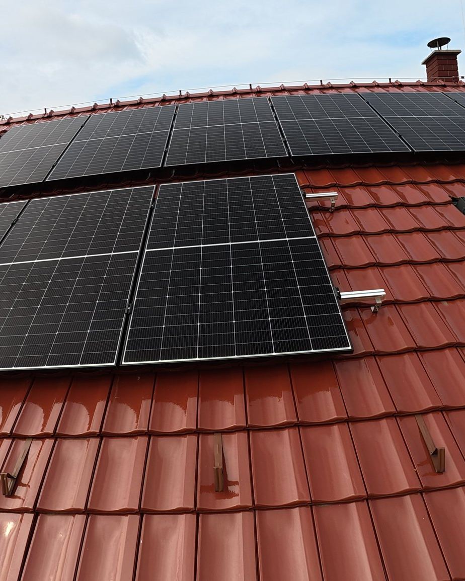 Fotovoltaické panely na červené pálené střeše, pohled z dronu