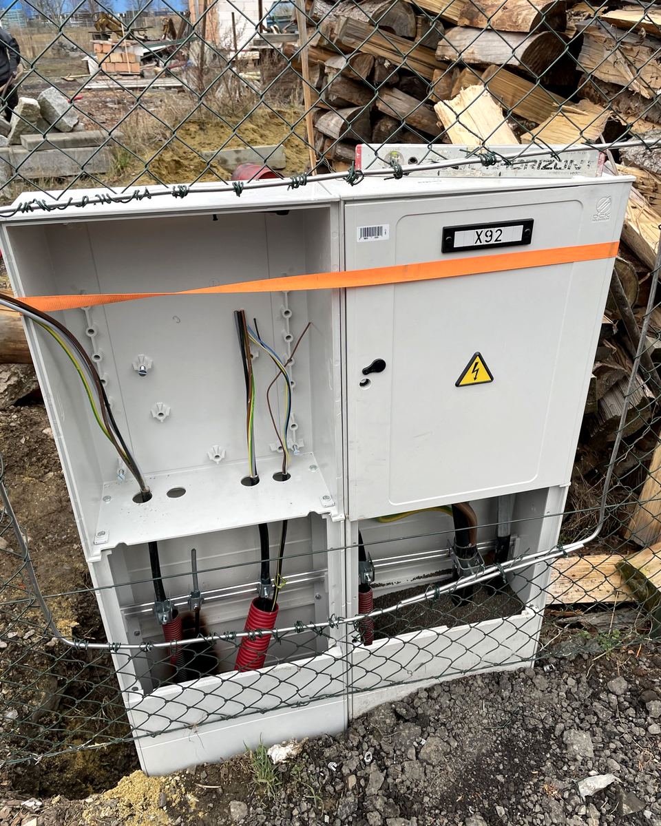Osazený elektroměrový pilíř s kabely ve výkopu